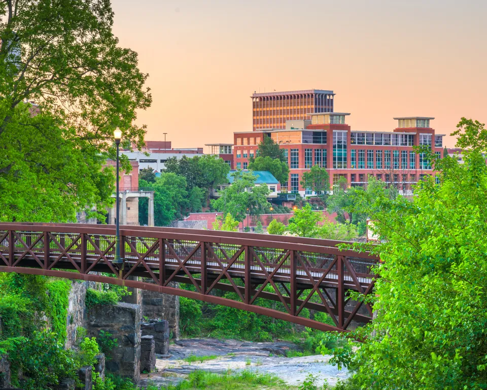 Columbus riverfront park, pedestrian bridges and brick buildings at dusk.